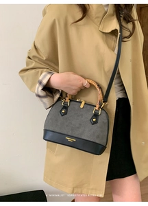 Detail of contrast shell bag with retro bamboo handle and adjustable shoulder strap