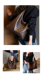 Detail shot of a dark brown vintage PU leather tote bag with wooden bead fringe tassel