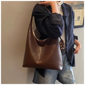 Detail of dark brown vintage Hobo bag featuring glossy leather texture and beaded tassel
