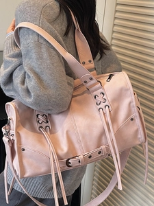 Pink PU leather barrel tote bag with cross straps and fringe detail in model view