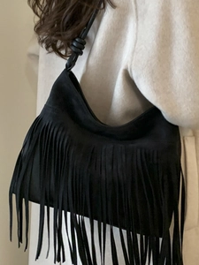 Minimalist black suede crossbody bag with bohemian long fringe and knotted strap