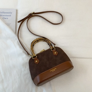 Detailed top view of brown shell bag featuring bamboo handle and mixed textures