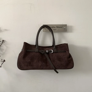 Detailed view of dark brown suede tote bag with leather strap and silver metal buckle