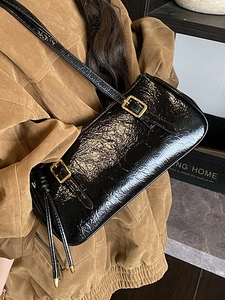 Sac sous le bras en cuir verni noir vintage avec boucles dorées sur modèle