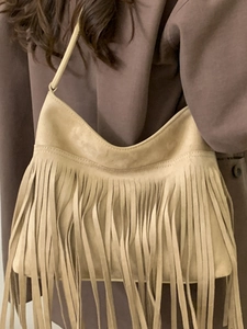 Minimalist beige suede crossbody bag with bohemian fringes and adjustable strap for women