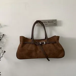 Detail view of brown frosted suede tote bag with leather strap and silver buckle accent
