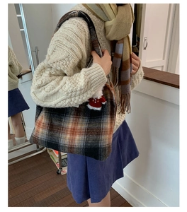 Close-up of high-capacity plaid wool tote bag with festive Santa charm and wide strap