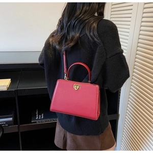 Détail du sac cabas en cuir rouge vintage avec fermoir doré et poignée solide