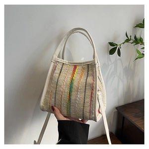 Détail du sac à bandoulière beige avec des rayures brodées verticales colorées