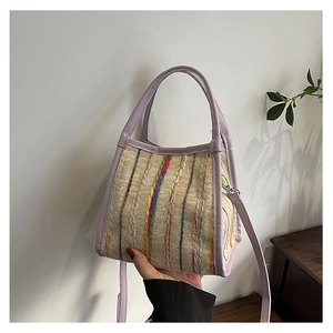 Détail du sac cabas rayé avec bandoulière et poignées en cuir violet clair de qualité