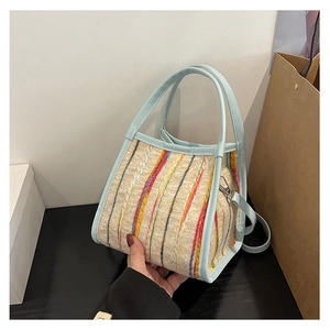 Détail du sac cabas tissé avec rayures multicolores et finitions en cuir bleu ciel