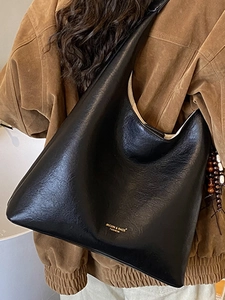 Fashionable black leather crescent tote bag with wood bead charm for autumn 2025