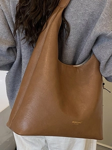 Brown vintage large capacity PU leather tote bag shown on a model for autumn 2025 fashion
