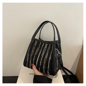 Détail du sac bandoulière en tweed avec texture tissée noire et blanche et boucles argent