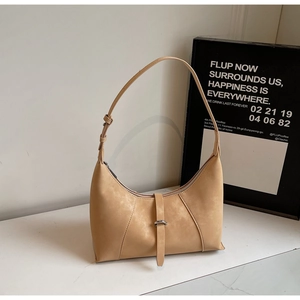 Detailed view of beige hobo bag with geometric stitching and metal buckle decoration