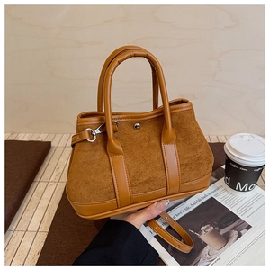 Detail showing vintage caramel suede texture and leather handle of large tote bag