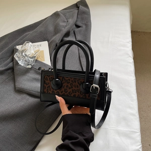 Detail of retro leopard print handbag with black leather trim and silver hardware