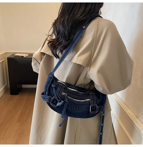 Detail view of dark blue denim tote bag with silver zippers and shion embroidery