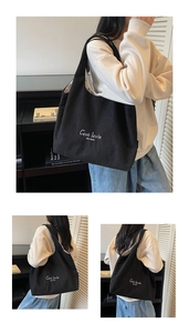 Dettaglio borsa tote in velluto a coste nero con ricamo bianco e fodera interna chiara