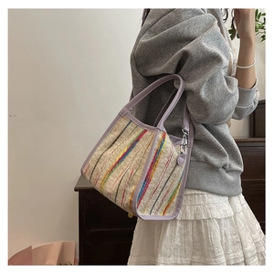 Détail du sac seau en tweed arc-en-ciel avec garniture en cuir lilas et fermoir en métal