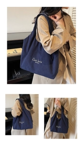 Dettaglio della borsa tote in velluto a coste blu con ricamo 'C'est la vie' e trama a coste