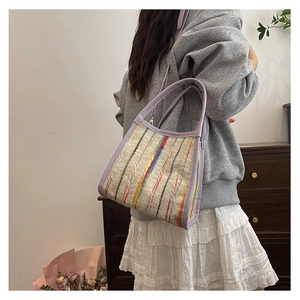 Détail du sac cabas tissé à rayures colorées avec anses violettes sur mannequin