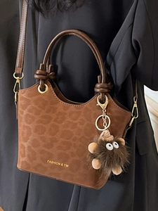 Brown leopard print bucket bag with gold lettering and plush charm for women