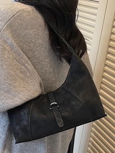 Retro black suede hobo bag with silver buckle worn over a grey knit sweater