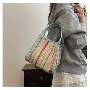 Détail du sac en toile avoine avec broderies colorées et bandoulière en cuir bleu