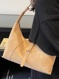 Minimalist beige suede crescent hobo bag with adjustable strap and metallic buckle