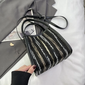 Détail du sac cabas en tweed rayé avec bords en cuir noir et bandoulière