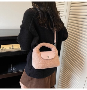 Détail de la texture en fausse fourrure rose et du rabat en cuir avec boucle de ce sac à main