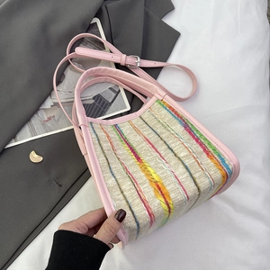 Détail du sac tissé à rayures arc-en-ciel avec finitions en cuir rose et bandoulière