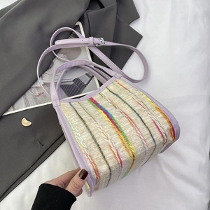 Détail du sac bandoulière tissé bohème avec lanières en cuir lilas et motifs colorés