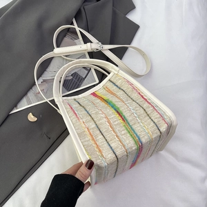 Détail d'un sac tissé à rayures multicolores avec bordure en cuir blanc et garniture
