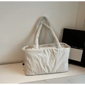 Detail of drawstring design on creamy white quilted puffer tote bag with soft texture