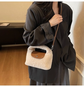 Détail d'un sac à main en peluche crème avec rabat en cuir marron et boucle métallique