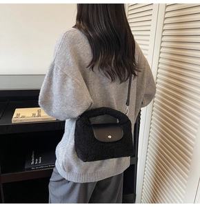 Détail du sac à main noir en peluche avec rabat en cuir et bandoulière amovible sur modèle