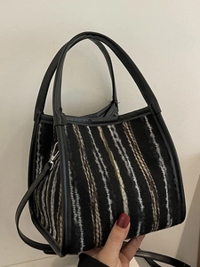 Sac bandoulière minimaliste en tweed noir avec rayures verticales et poignées en cuir