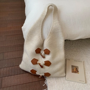 Détail du sac cabas en maille crème avec boutons brandebourg en cuir marron vintage