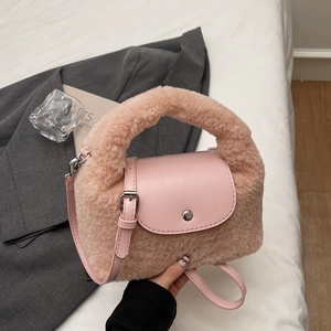 Détail d'un sac à main en peluche rose avec poignée douce et boucle en métal argenté