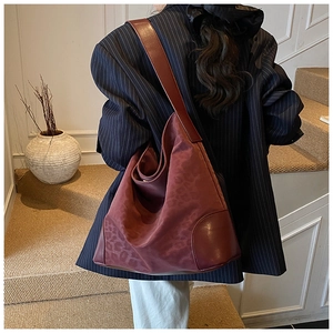 Deep burgundy leopard print hobo bag worn on shoulder showing large capacity and texture