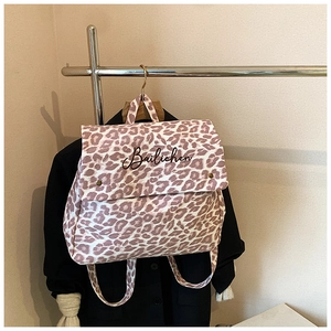 Close-up of pink leopard print backpack with metal buckles and Bailichen lettering