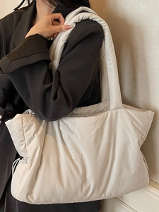 Minimalist off-white quilted tote bag with spacious interior and wide shoulder strap
