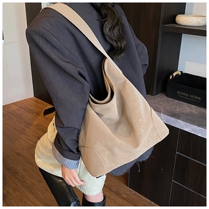 Khaki large capacity hobo tote bag with wide shoulder strap shown on a female model