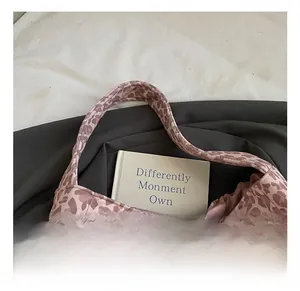 Close-up of comfortable handles on a leopard print tote bag made of knit fabric