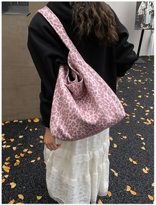 Outdoor shot of a pink leopard print oversized tote bag worn by a model on a shoulder