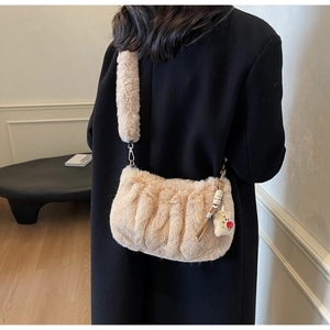Gros plan sur un sac bandoulière en peluche beige avec volants et breloque ours mignon