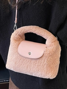 Mini sac à main en peluche rose avec rabat en cuir et bandoulière amovible porté par modèle