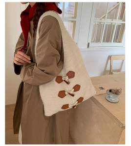 Détail d'un grand sac cabas en maille avec des boucles décoratives en cuir marron et cornes